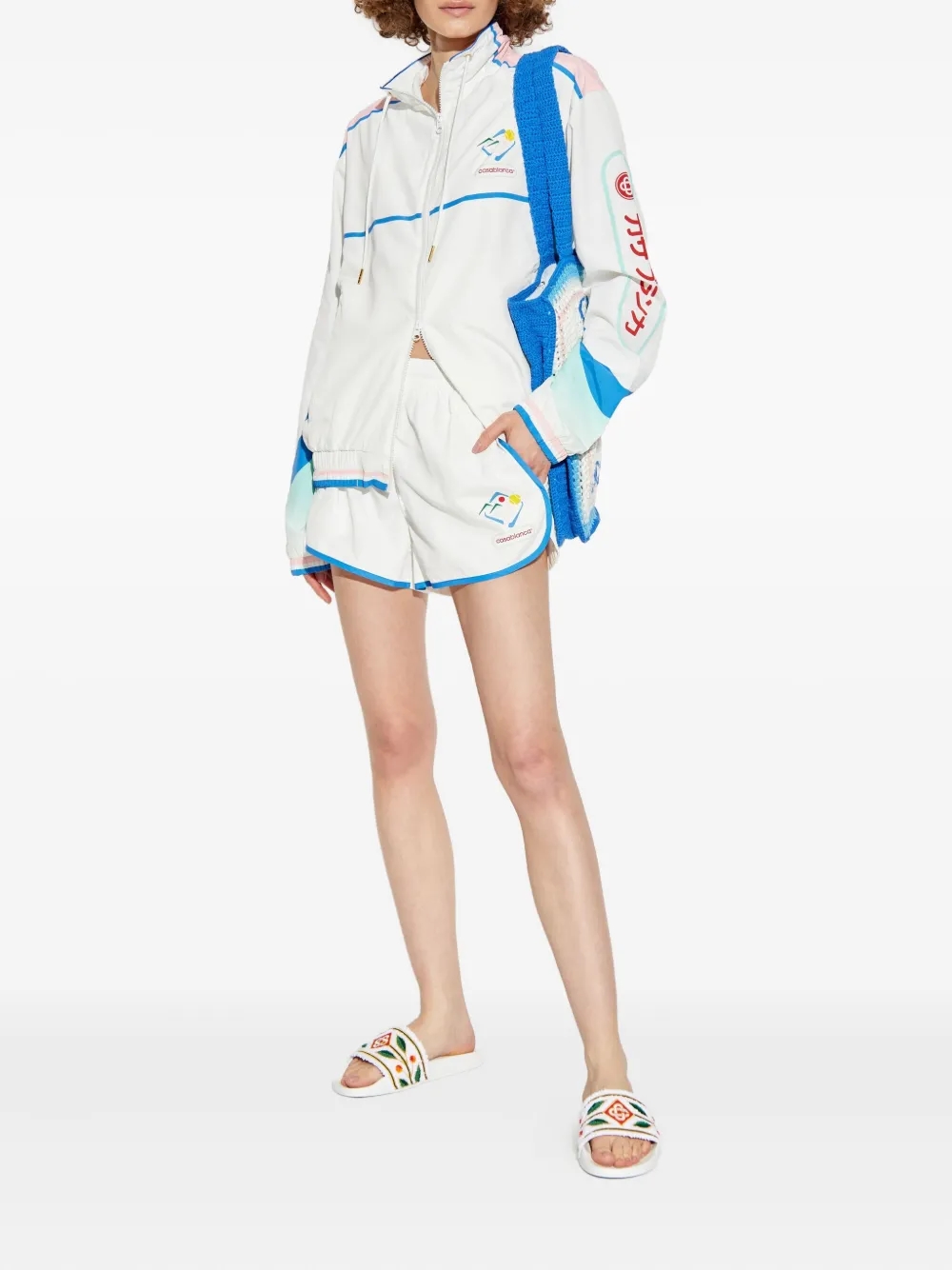 Casablanca-inspired resort sport shorts in silk and crochet set against tennis green